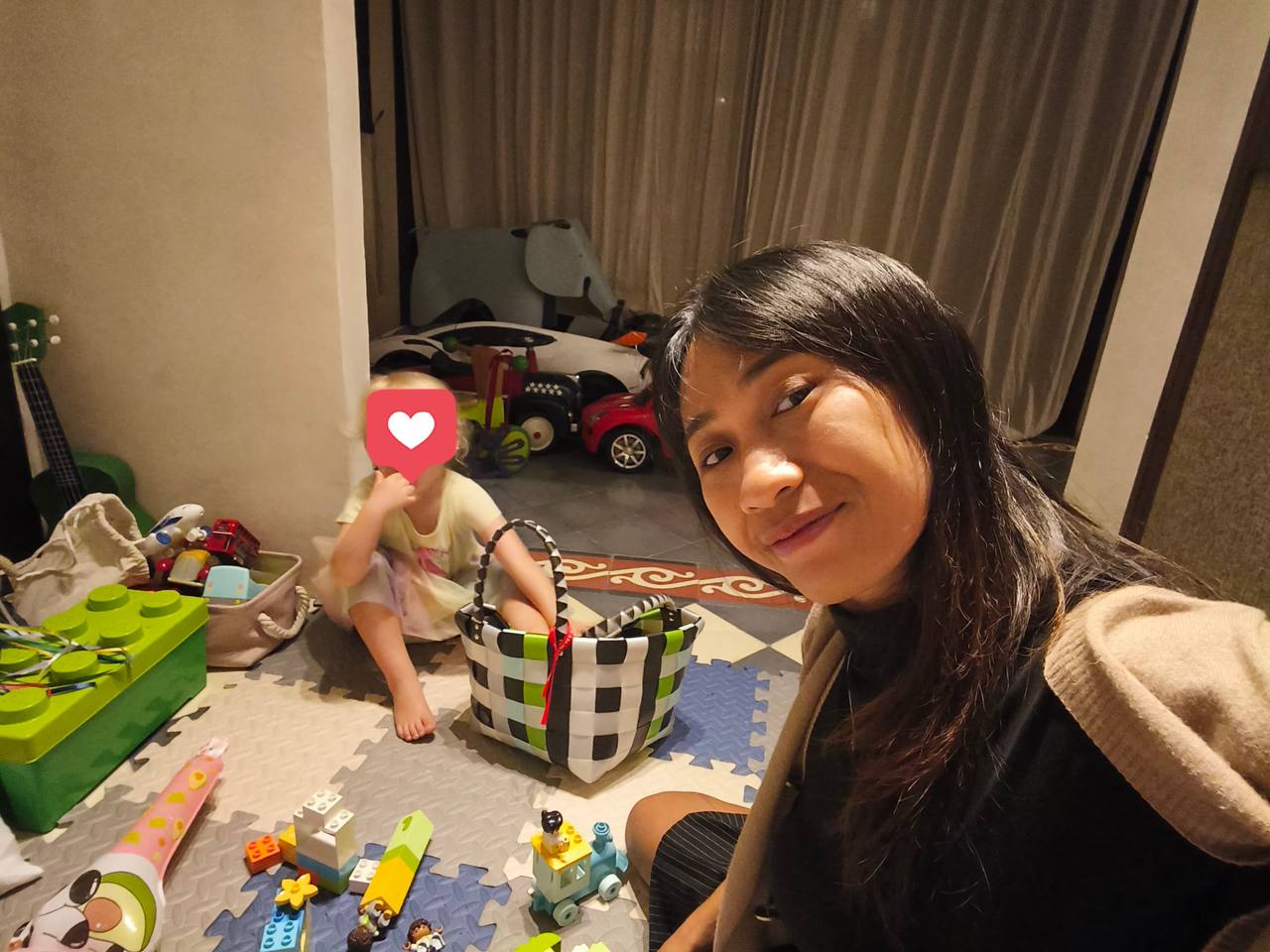 Siti playing with toys with a child in Bali